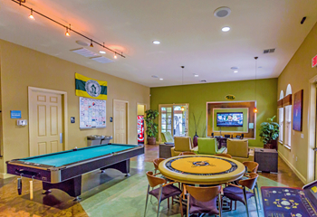 Game room has green and yellow walls, a pool table, and round table with approx 6 chairs.